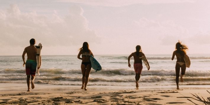 Teens bonding over surfing, enjoying waves, and exploring together
